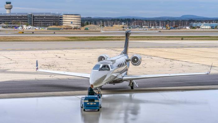 Embraer Phenom 300 being towed into hangar on Tug
