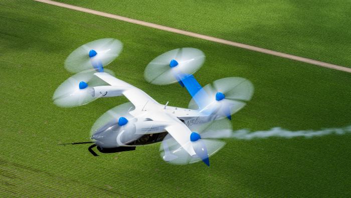 Joby's eVTOL aircraft with blue livery and trail of water vapor behind it