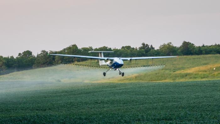 Pyka's Pelican Spray aircraft is pictured spraying a field of crops. 