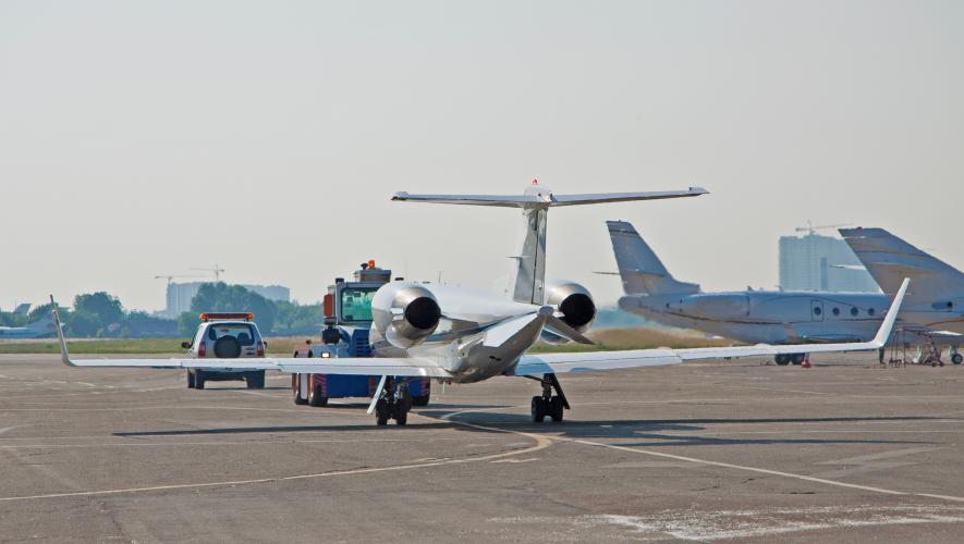 private jet being towed at airport