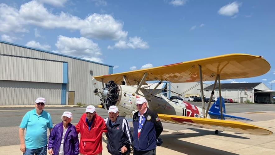 U.S. Military veterans posing by Stearman trainer