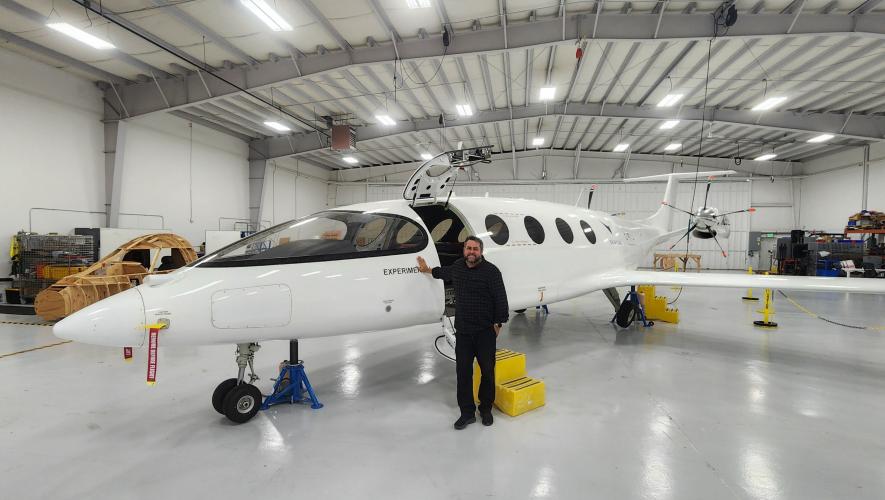 Andre Stein poses with the Alice prototype inside the hangar at Eviation's headquarters