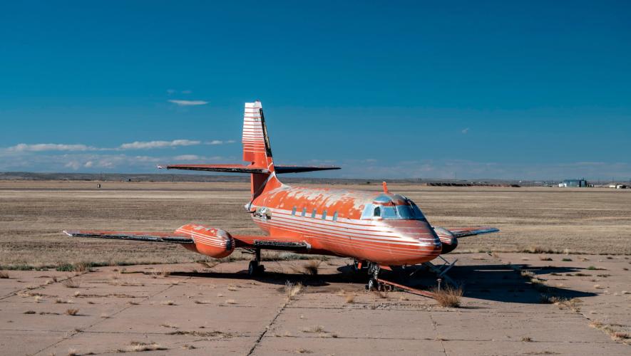 Lockheed JetStar once owned by Elvis Presley parked on overgrown airport ramp in the New Mexico desert