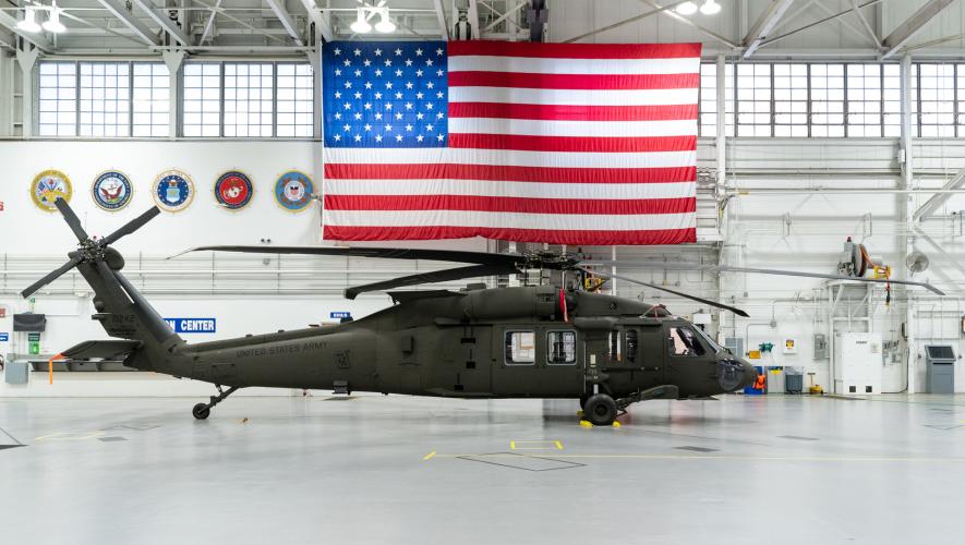 Black Hawk helicopter sits in hangar beneath U.S. flag