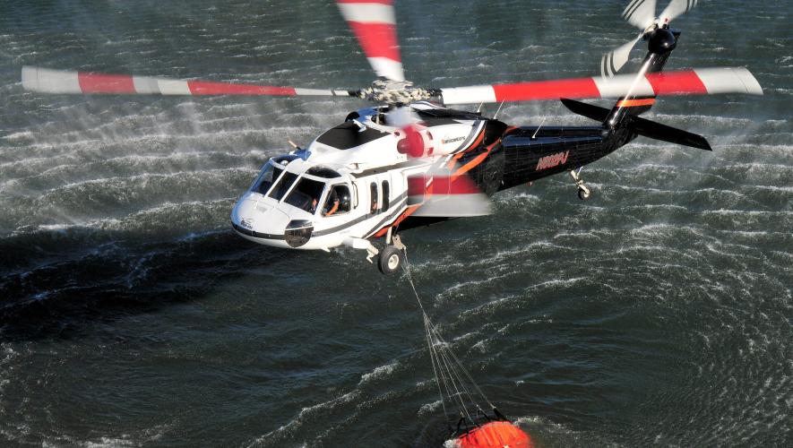 PJ Helicopters UH-60A Utility Hawk helicopter collects water from lake for utility firefighting mission
