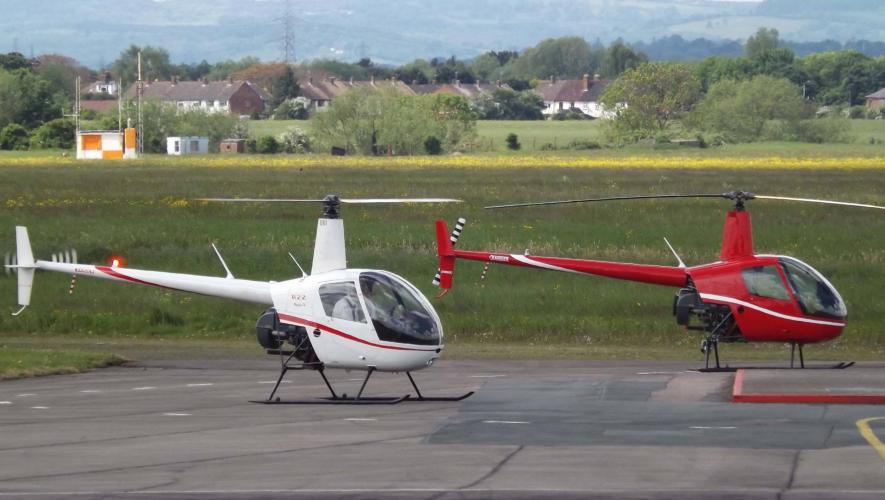 Two Robinson R22 helicopters on airport ramp at Gloucestershire Airport