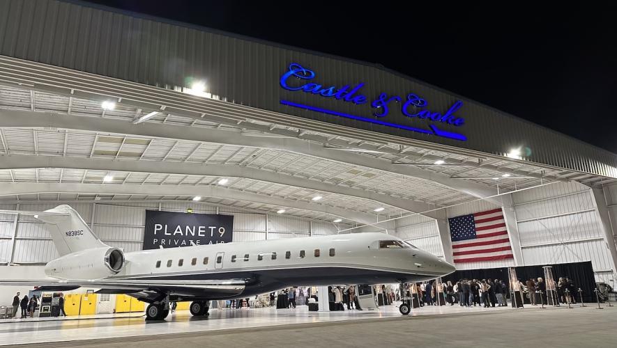Attendees at Planet 9 aircraft charter open house gather behind Bombardier Global business jet in the Castle & Cooke hangar at Van Nuys Airport.
