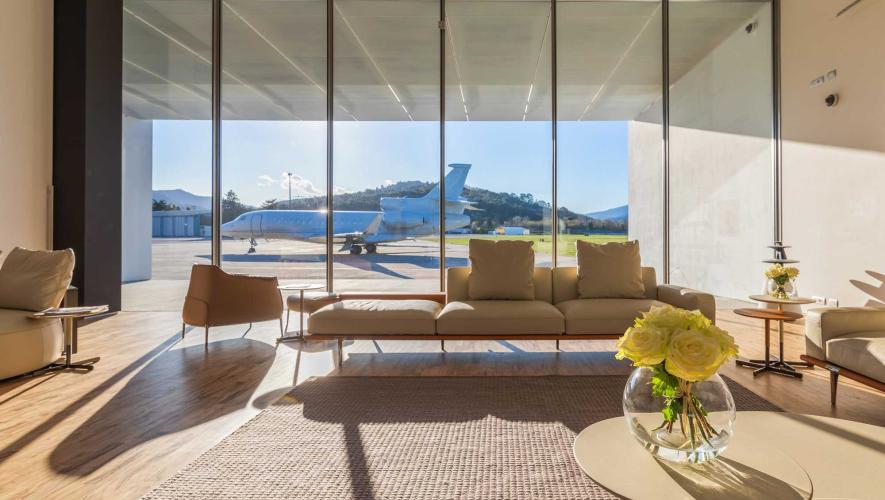 Lounge area at Hadid FBO at Italy's Riviera Airport overlooking airport ramp