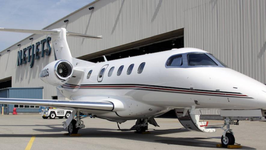 NetJets Embraer Phenom 300 in front of company hangar