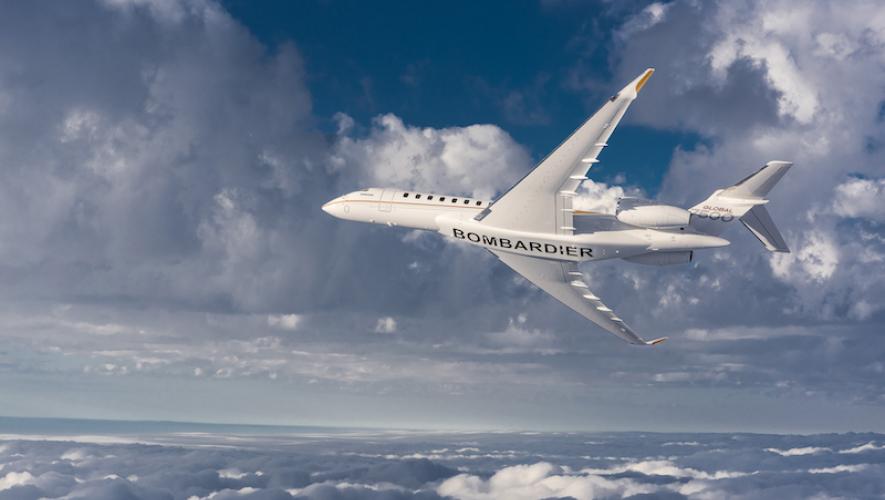 bottom view of Bombardier Global 7500 in flight over clouds