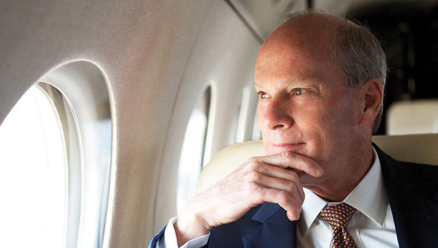 Larry Flynn looking out window in Gulfstream business jet