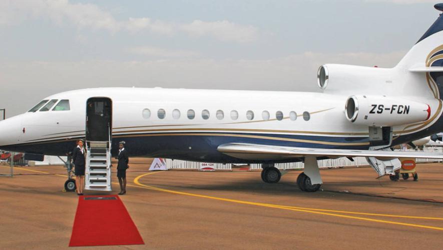 Dassault Falcon on airport ramp with door open and red carpet