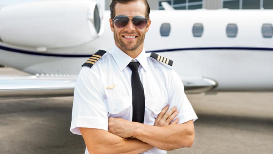 Business jet captain poses by wing