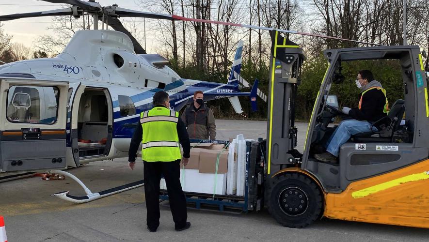 Ground Crew using a forklift to load pallets into helicopter
