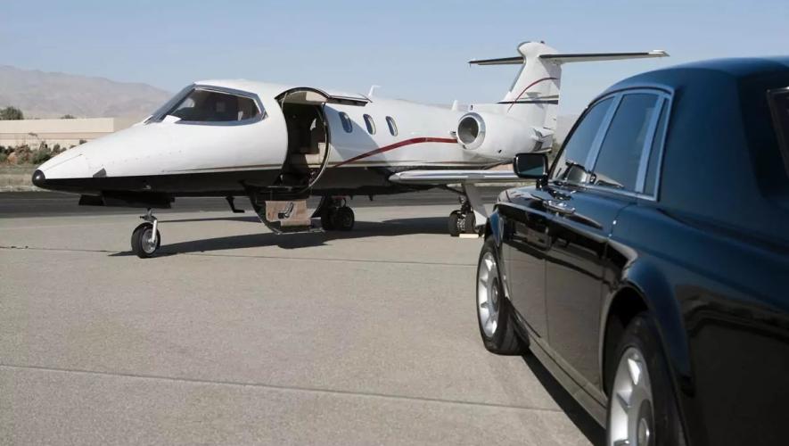 Business jet with door open greeted by courtesy car on airport ramp