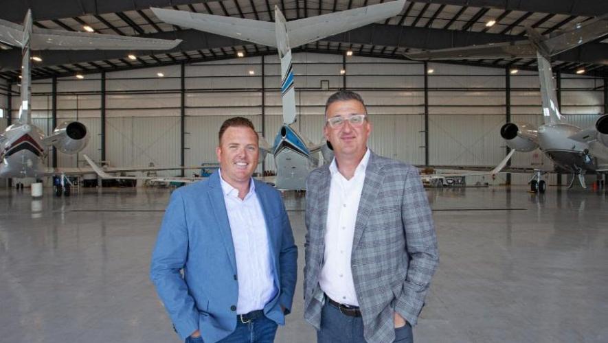 Robert Sherry, COO, James Prinzivalli, president, Executive Fliteways in hangar backdropped by business jets