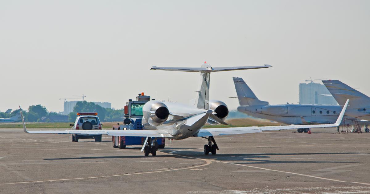 private jet being towed at airport