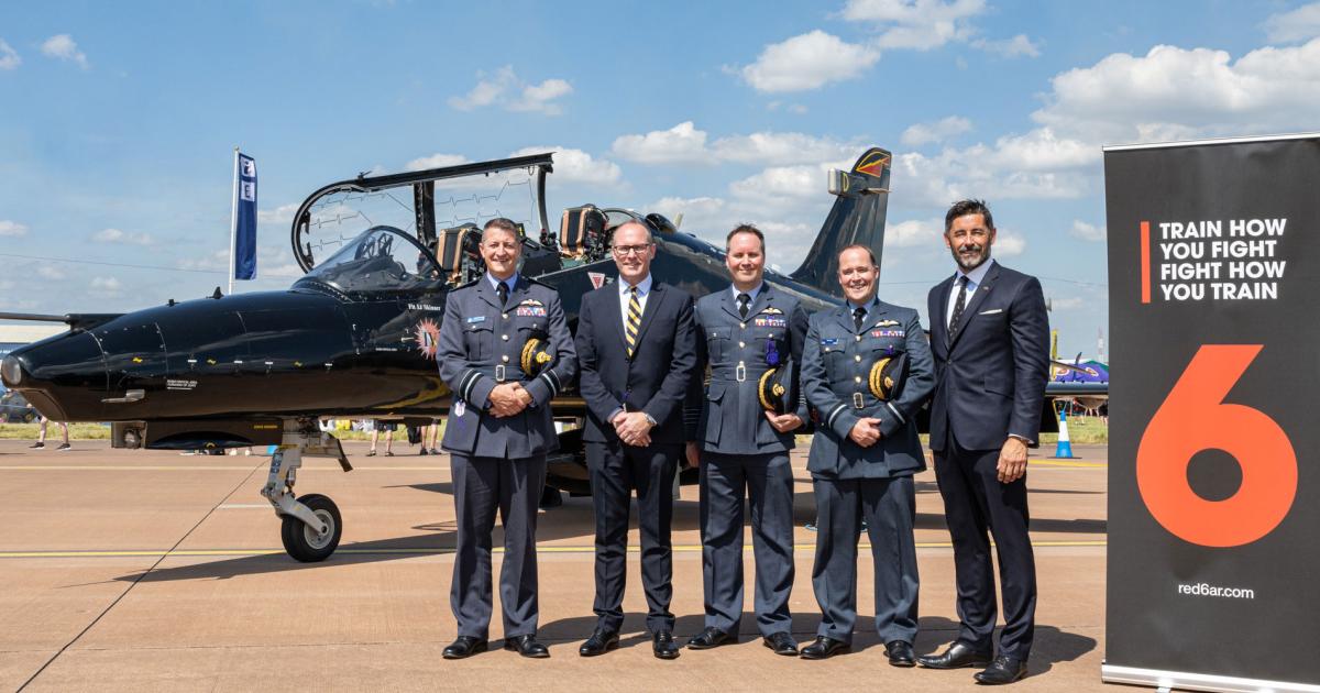 Representatives of BAE Systems and Red 6 pose with RAF officers in front of a Hawk T.Mk 2 during the Royal International Air Tattoo event held at RAF Fairford on July 19-21, 2024.