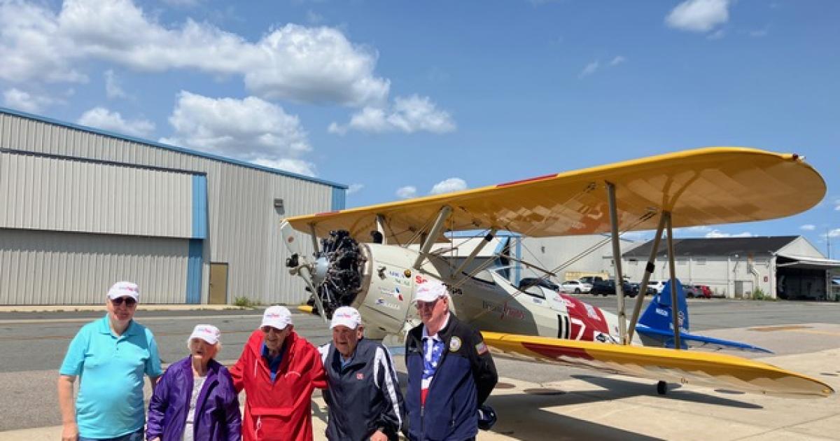 U.S. Military veterans posing by Stearman trainer