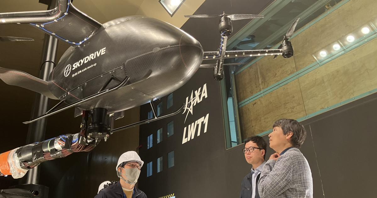 Venture capitalist Kotaro Chiba (left) views a model of SkyDrive's SD-05 eVTOL aircraft.