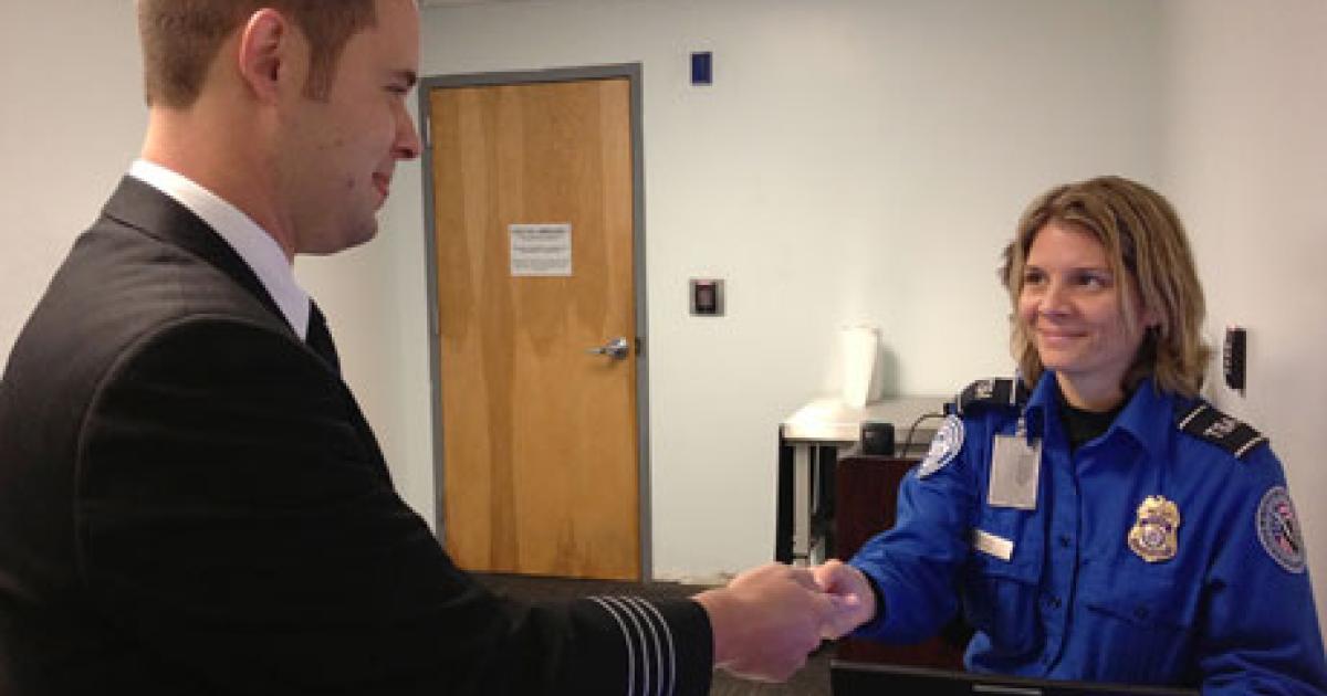 Capt. Robert Hamilton, chairman of the Air Line Pilots Association security council, hands his identification to a TSA officer at a Known Crewmember checkpoint. (Photo: Air Line Pilots Association, International)  