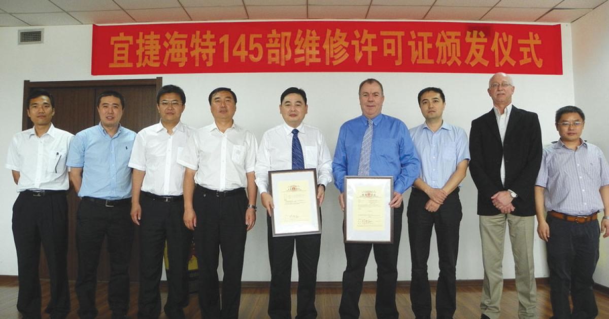 ExecuJet Haite chairman Li Biao (center left) and Graeme Duckworth, managing director of ExecuJet Asia (center right), hold the new CAAC Part 145 certificates for ExecuJet Haite Aviation Services China.