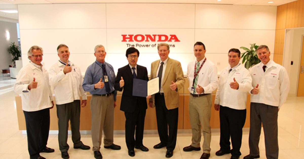 Honda Aircraft president and CEO Michimasa Fujino celebrates receipt of Part 145 approval for the company’s customer service center.