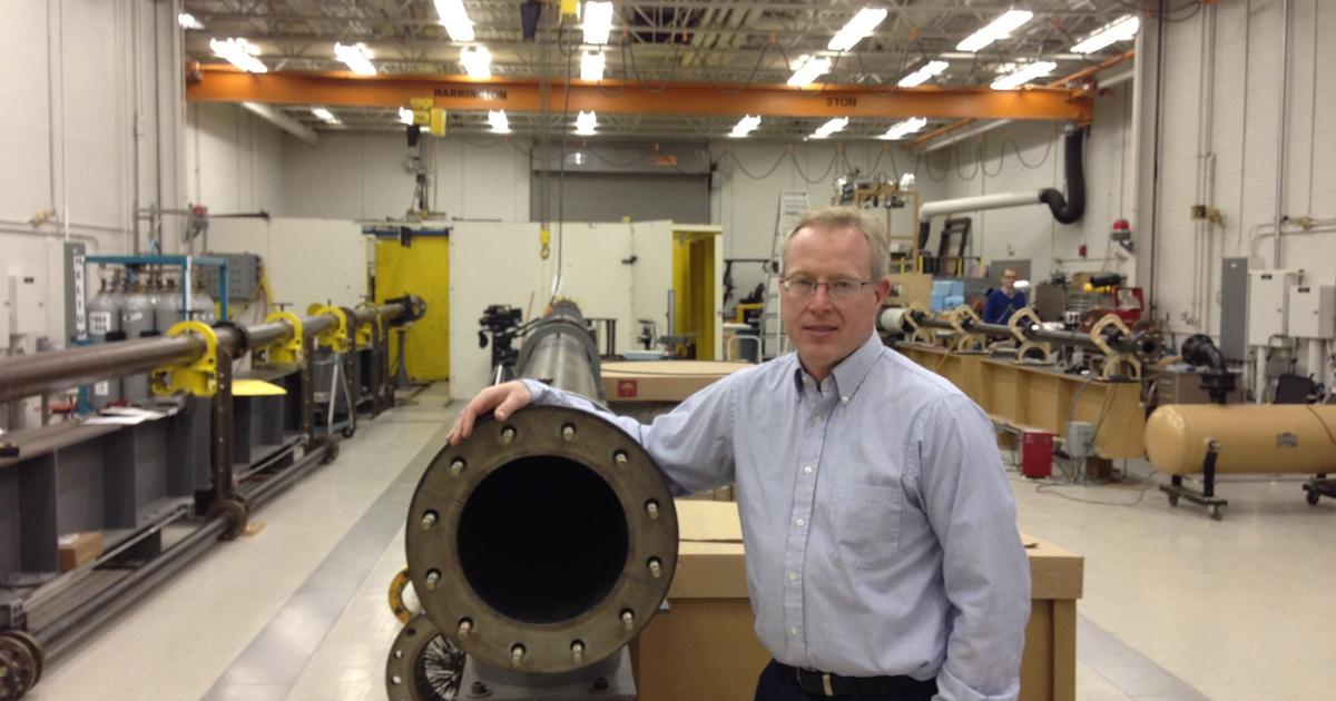 Kevin Poormon, a senior research engineer and group leader for impact physics at the University of Dayton Research Institute, poses with at the business end of his lab's 40-foot long compressed gas cannon which fires aircraft data recorders at 350 miles per hour.