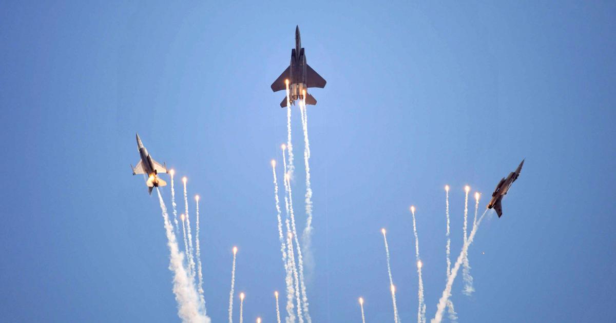 Part of its 50th anniversary celebration slated for the Singapore Airshow, two F-16s and an F-15 practice for their ‘golden display,’ a vertical maneuver in which each plane releases flares. Photo: Mark Wagner
