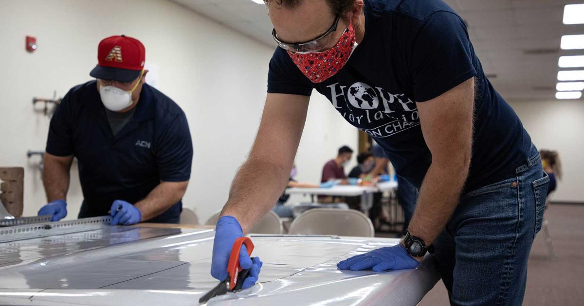 Workers from non-profit Hope Worldwide, manufacture medical face masks and face shields on an assembly line established in the Universal Avionics facility in Tucson.