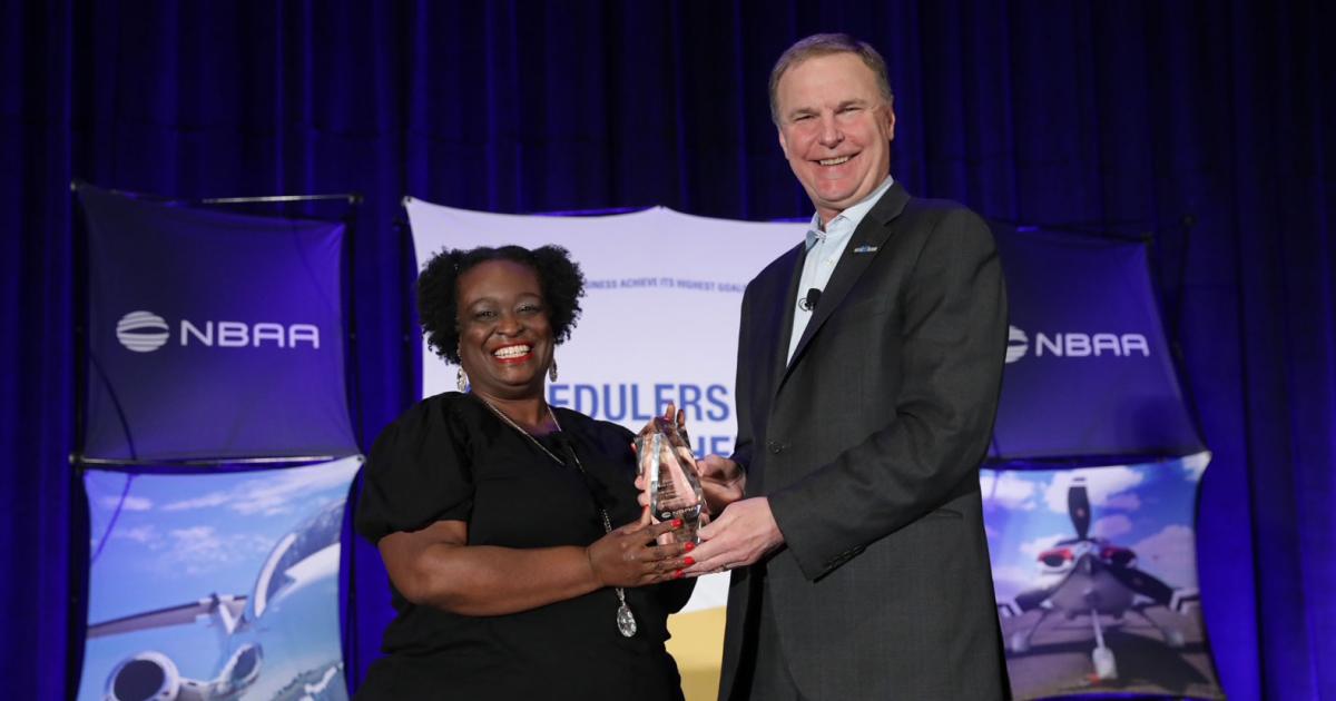 Enterprise Holdings' flight scheduling manager Francea Bolden accepts the 2022 Schedulers & Dispatchers Outstanding Achievement and Leadership Award from NBAA president and CEO Ed Bolen during the opening session of the Schedulers and Dispatchers Conference in San Diego. (Photo: NBAA)