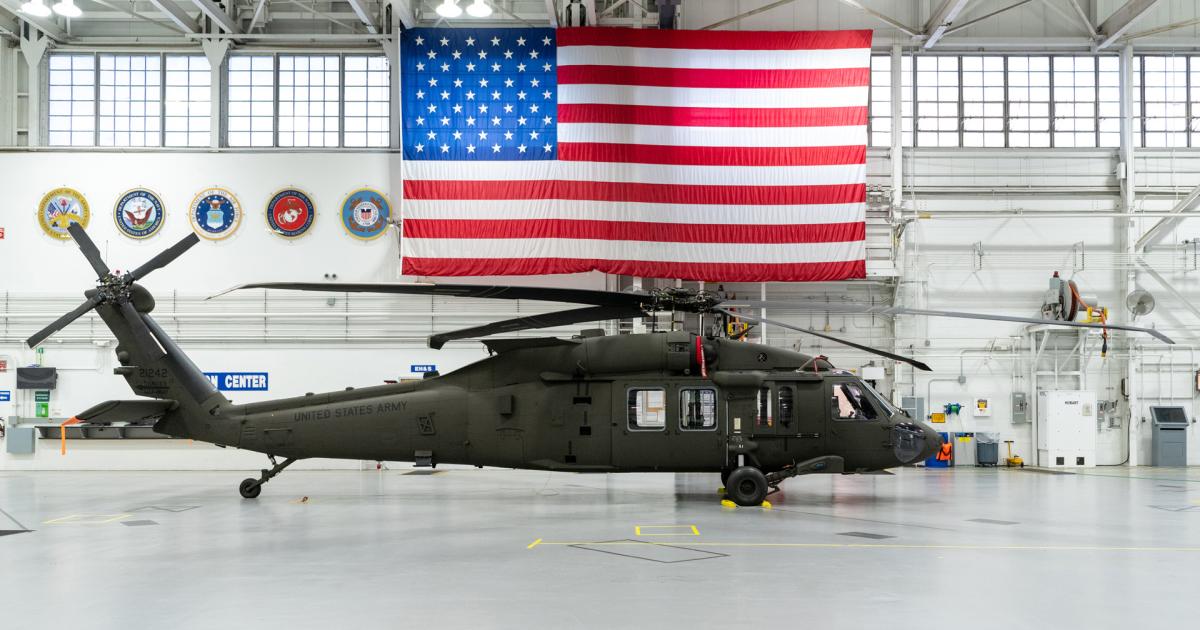 Black Hawk helicopter sits in hangar beneath U.S. flag