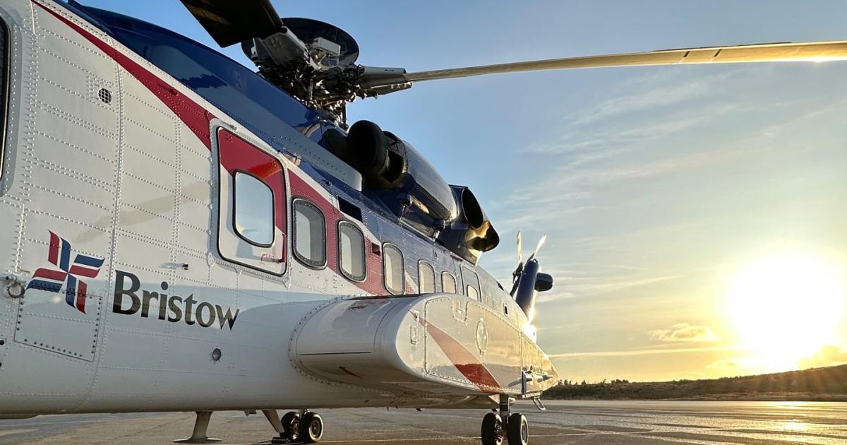 Bristow helicopter parked on airport ramp at sunset