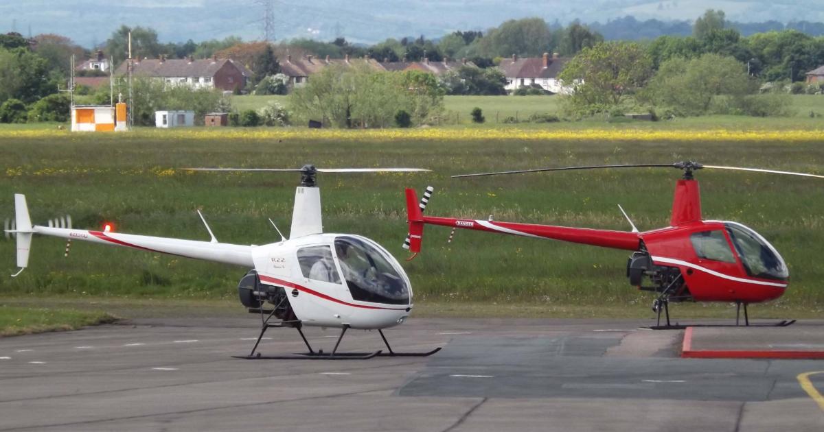 Two Robinson R22 helicopters on airport ramp at Gloucestershire Airport