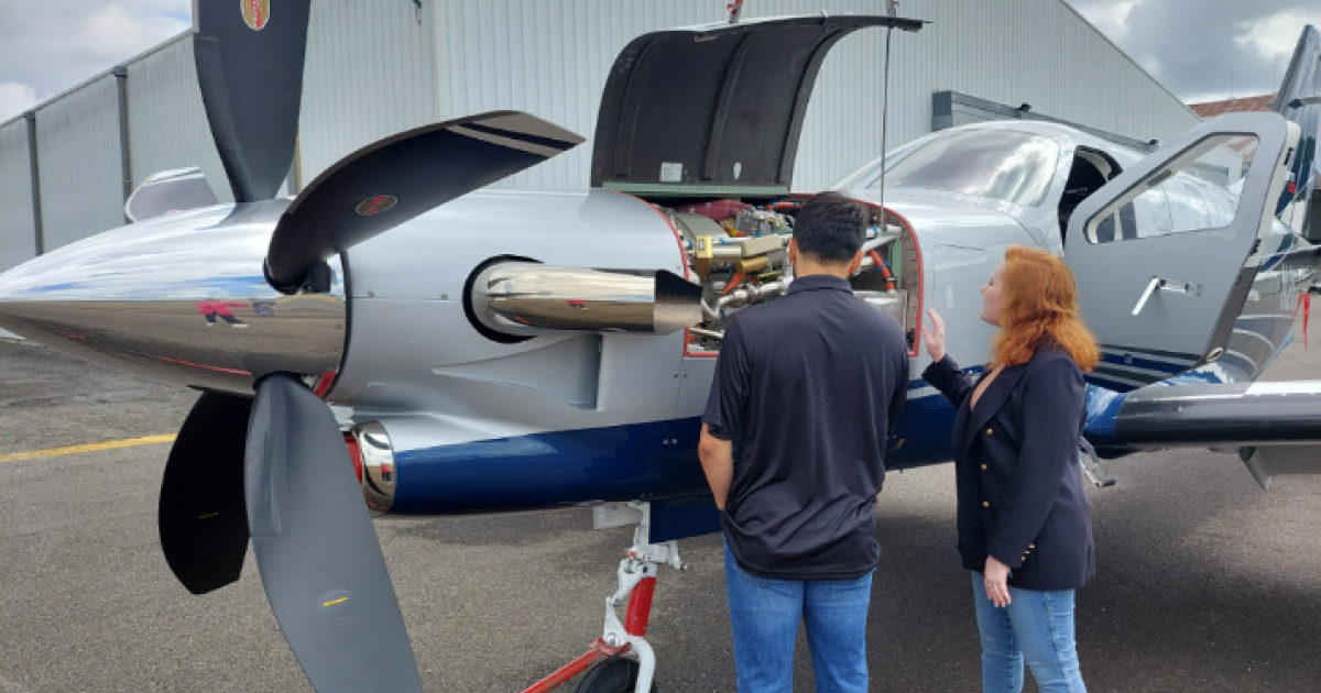 students looking at engine under cowling on Daher aircraft