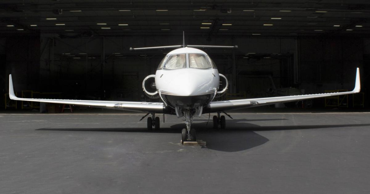 Hawker business jet parked outside of open hangar
