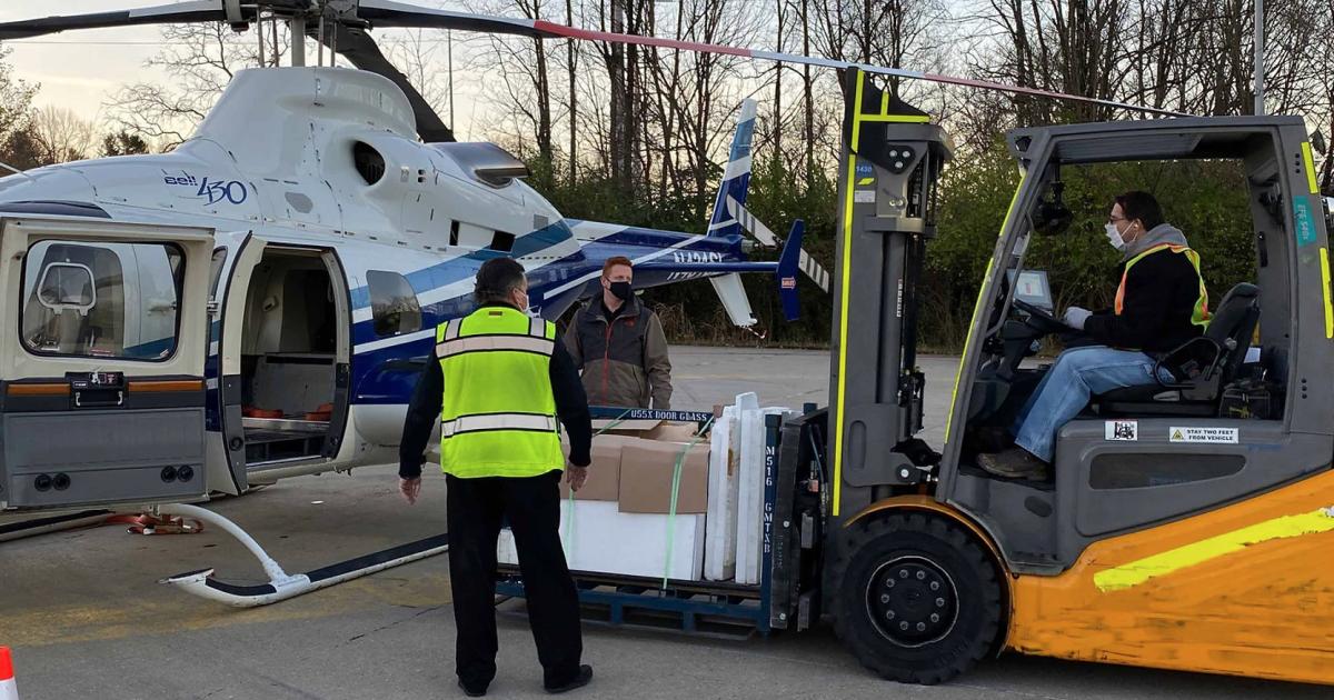 Ground Crew using a forklift to load pallets into helicopter