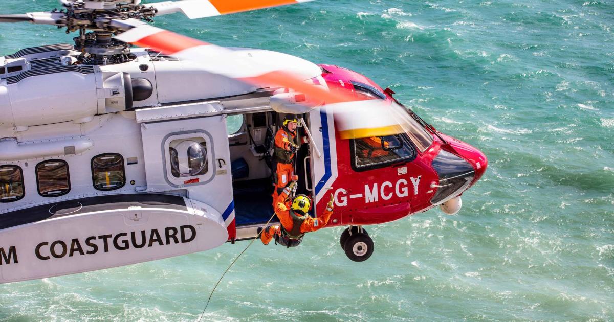Irish Coast Guard helicopter in flight over ocean with service members repelling into water